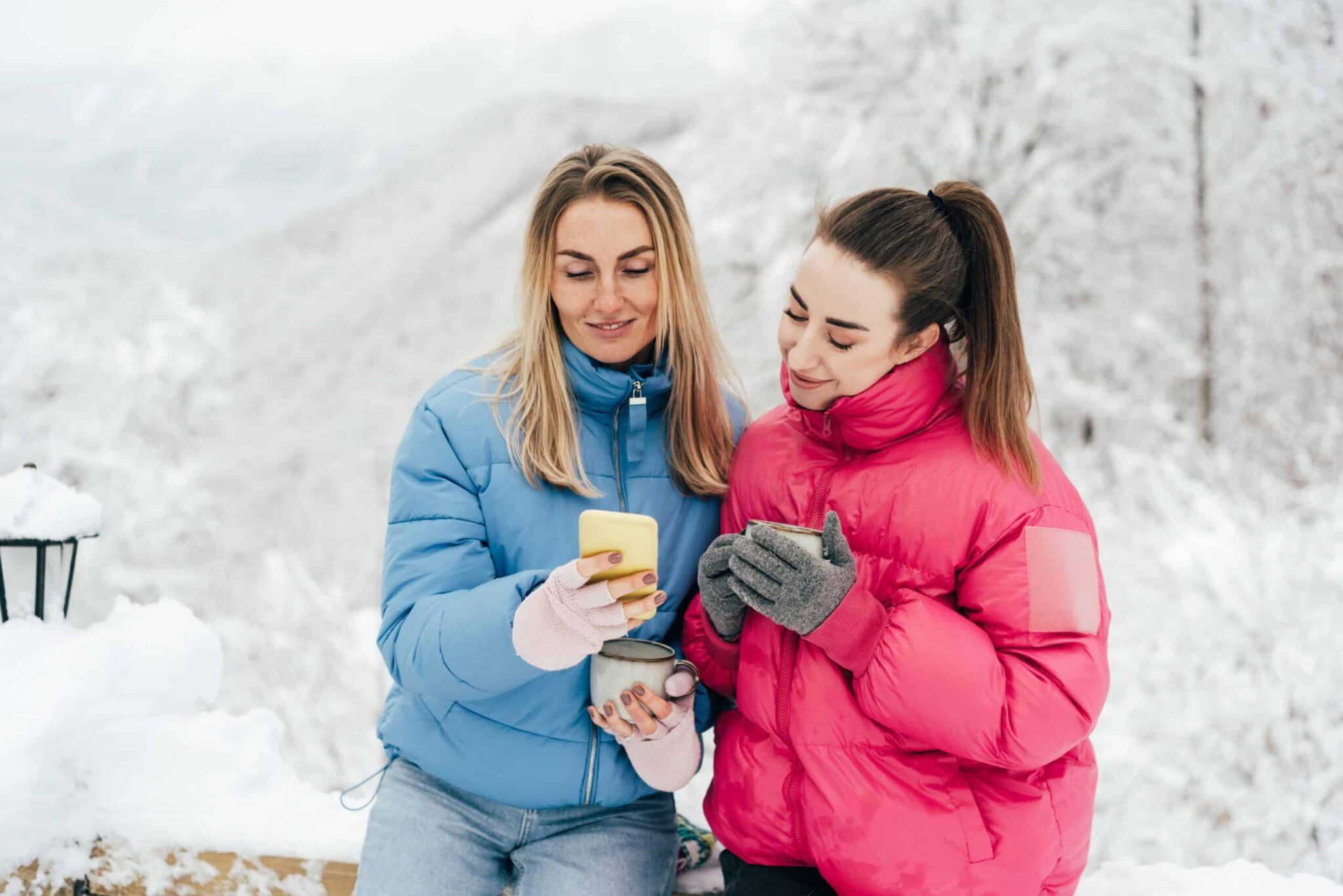 two-young-women-outdoors-in-snowy-weather-are-watc-2022-02-01-22-38-20-utc-scaled