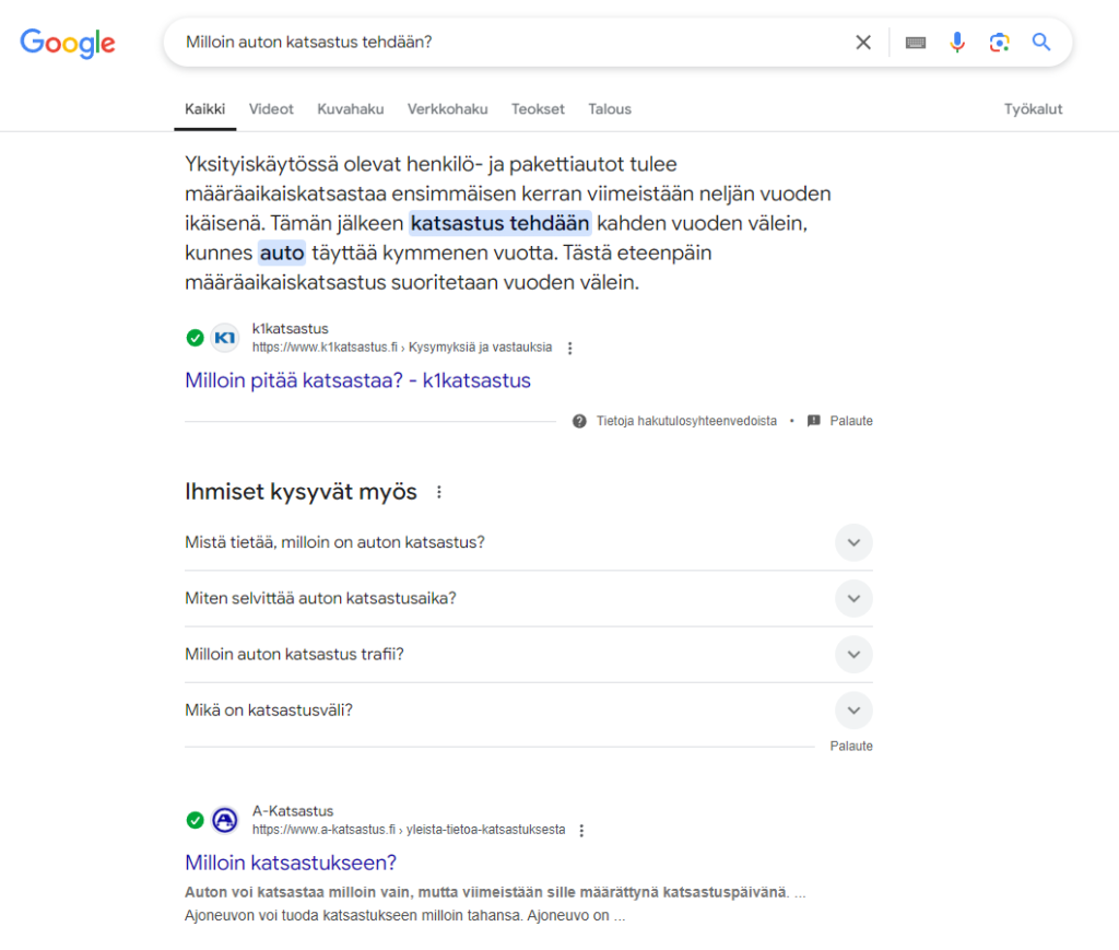 Kuva näyttää, kuinka Google tarjoaa UKK-esittelykatkelmia ja "Ihmiset kysyvät myös" -osion autokatsastukseen liittyvillä hakutermeillä. Ensimmäinen hakutulos on esittelykatkelma, jossa Google nostaa keskeisen vastauksen näkyviin suoraan hakutuloksessa ilman, että käyttäjän täytyy klikata sivulle.